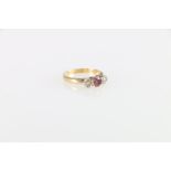 Unhallmarked yellow metal ruby and diamond three stone ring, size K, 3.2g