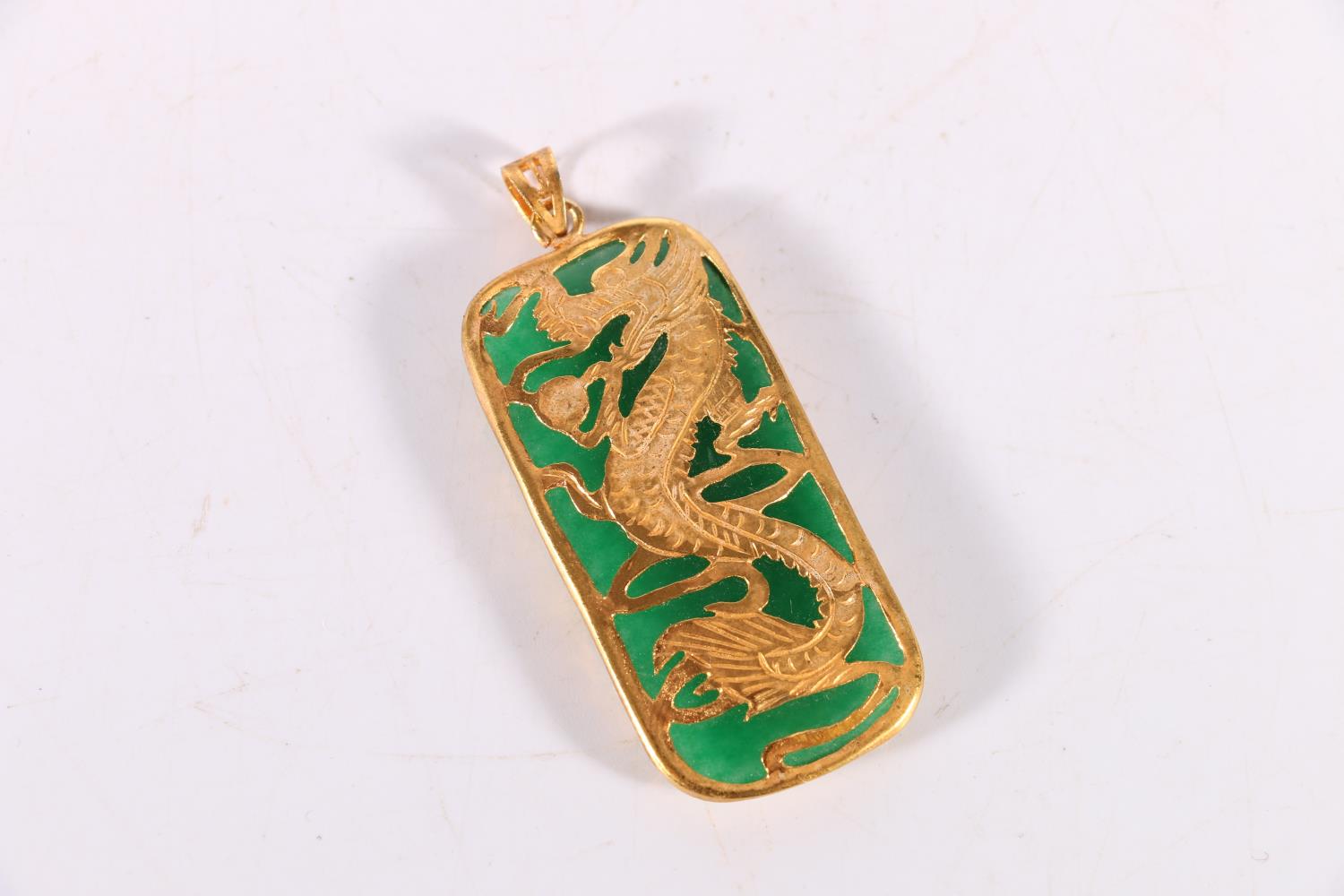 Chinese jade pendant with roll over yellow metal mount depicting a dragon with pearl, 13.5g gross,