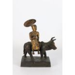 Early 20th centuy Burmese bronze figure of a bull and rider with a parasol, on a simple