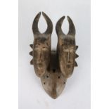 African  tribal mask the twin horned heads with decorative flanges to the face on an oval mask, 35cm