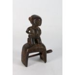 Unusual African carved wooden figural heddle pulley, with a kneeling figure with protruding belly