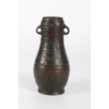 A Japanese bronze vase with two small loop handles, cast to resemble a pottery vessel with glaze