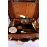 Art Deco period travel vanity case with fitted interior containing ivory brushes and silver topped