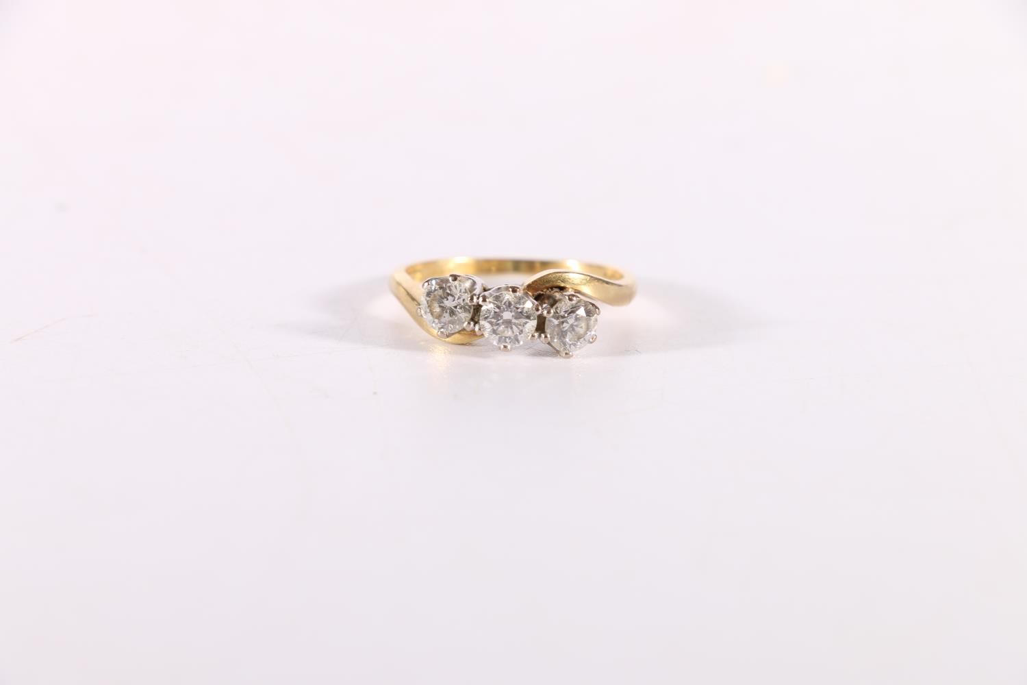 18ct yellow gold diamond three stone ring, the three diamonds arranged in a crossover setting,