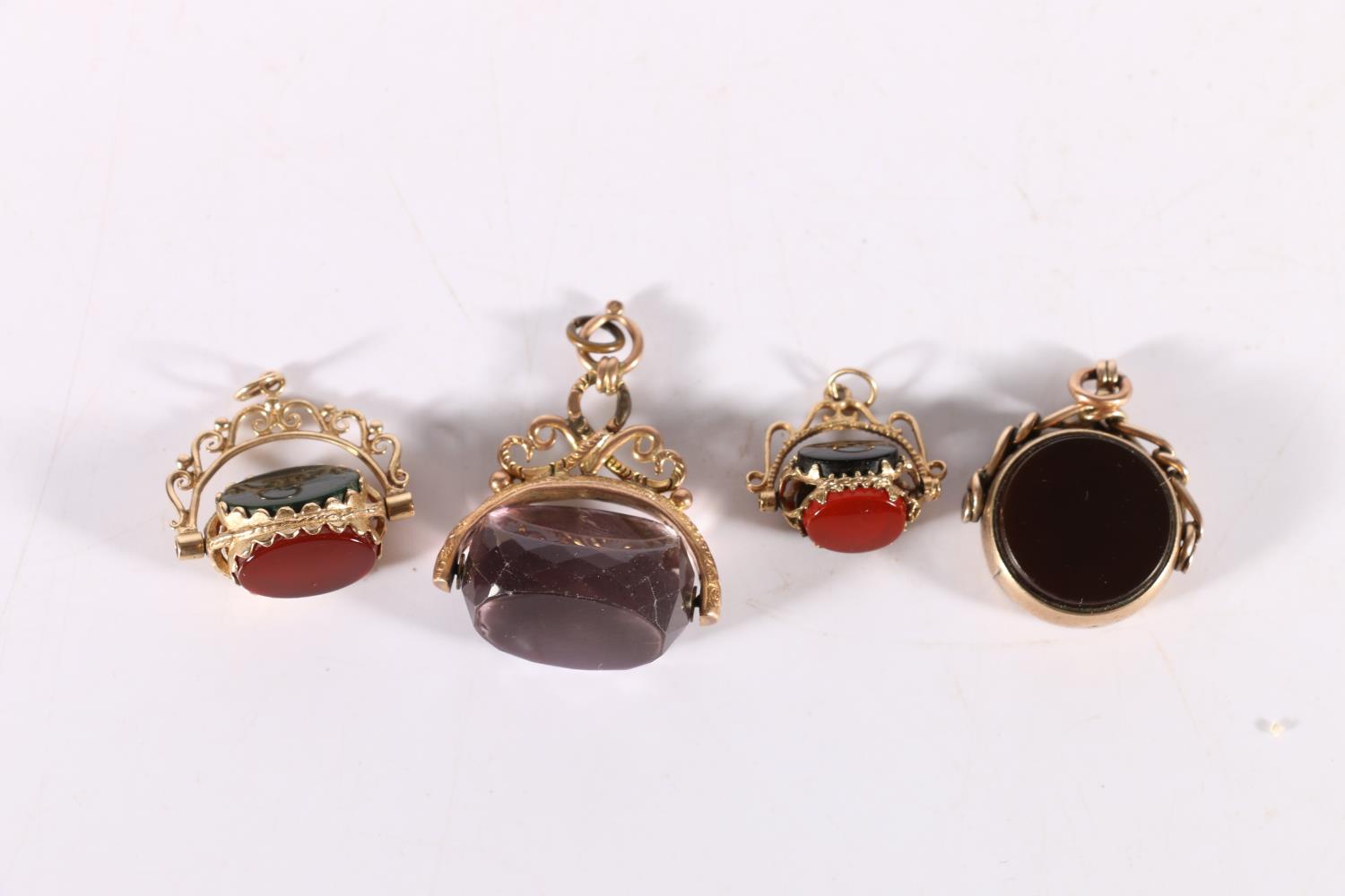 Four 9ct gold mounted bloodstone, agate or amethyst swivel fobs, 23.7g gross