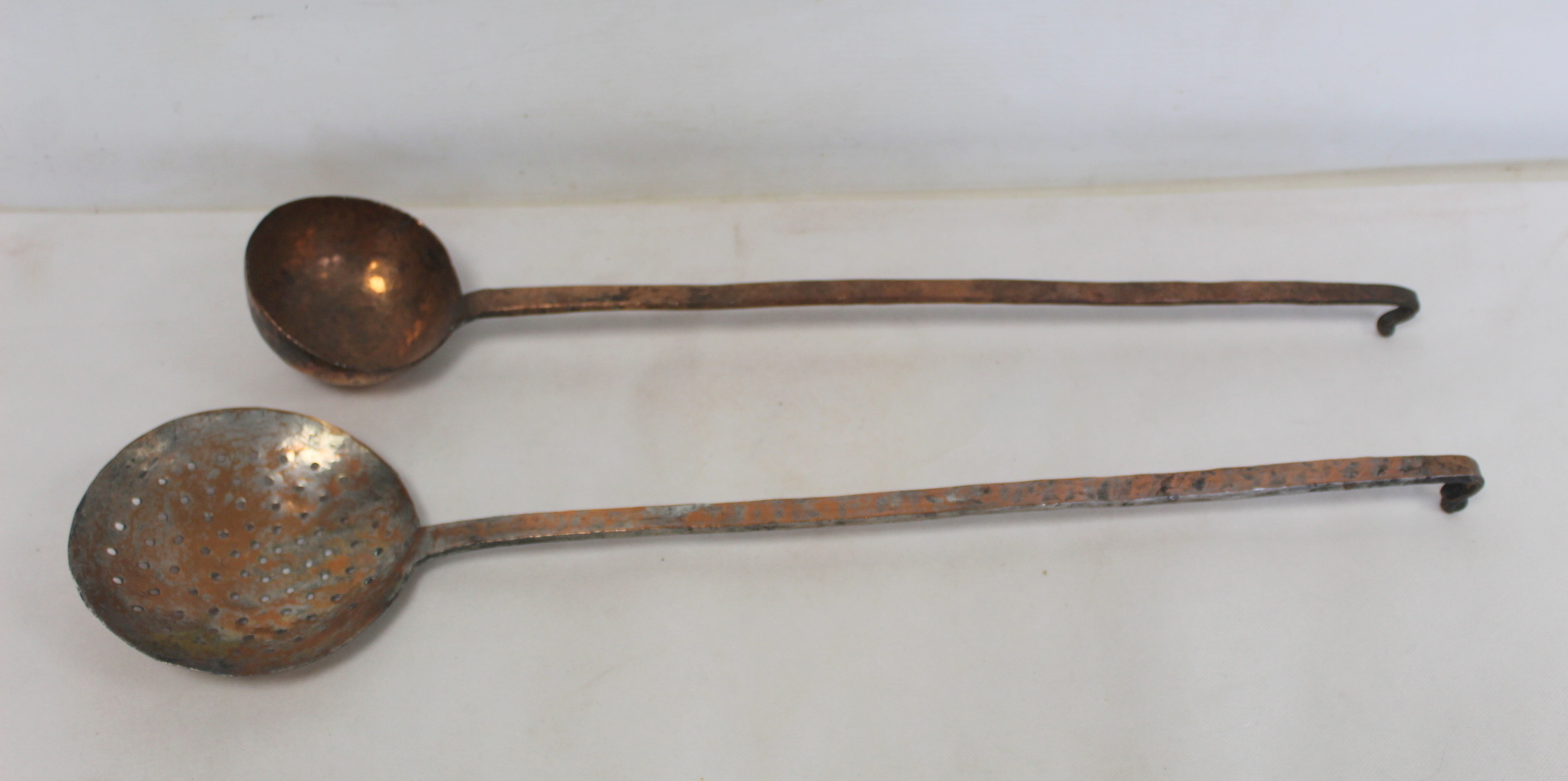 19th century beaten copper ladle, 56cm long and a similar skimmer, 60cm long.  (2).