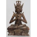 Eastern carved hardwood figure of a Buddha seated on a triangular lotus throne, 28cm high, signed