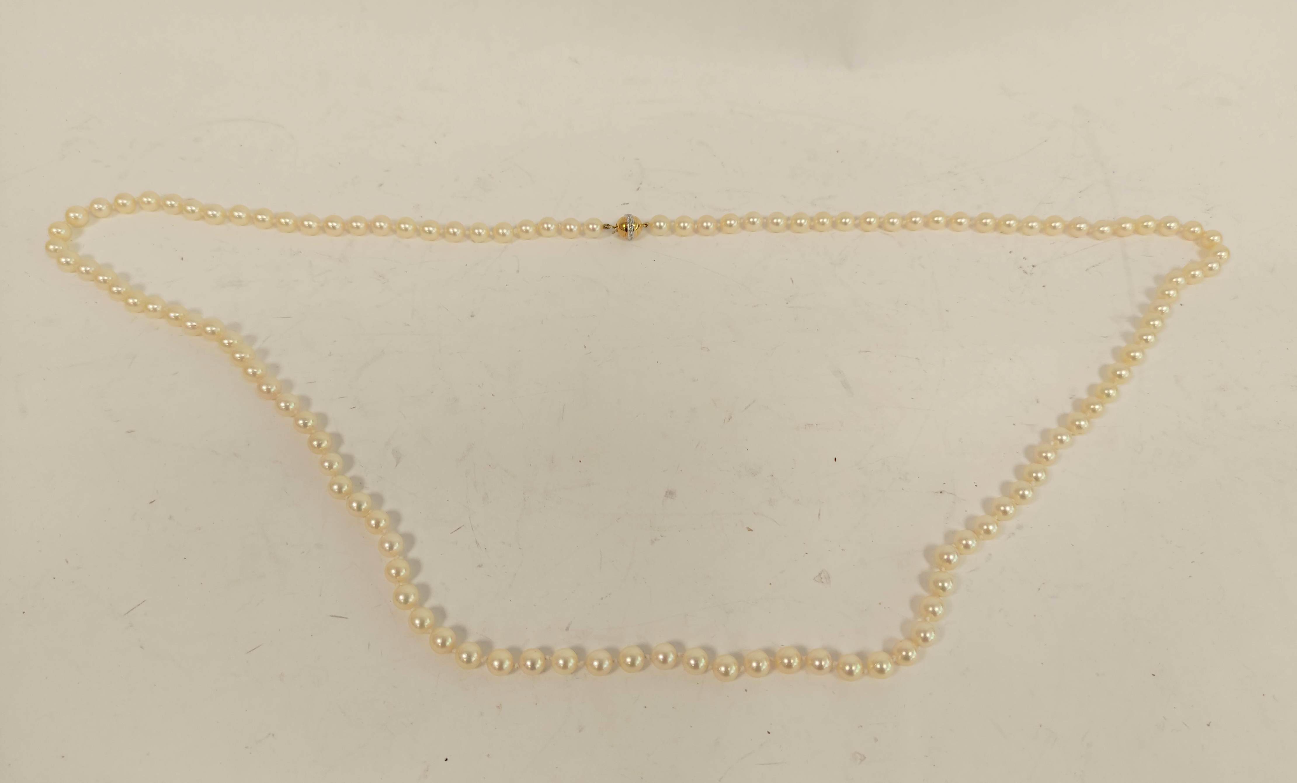 Necklace of equal sized cultured pearls, opera length on diamond set gold ball snap '.750'.