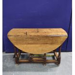 Antique oak drop leaf table raised on turned supports