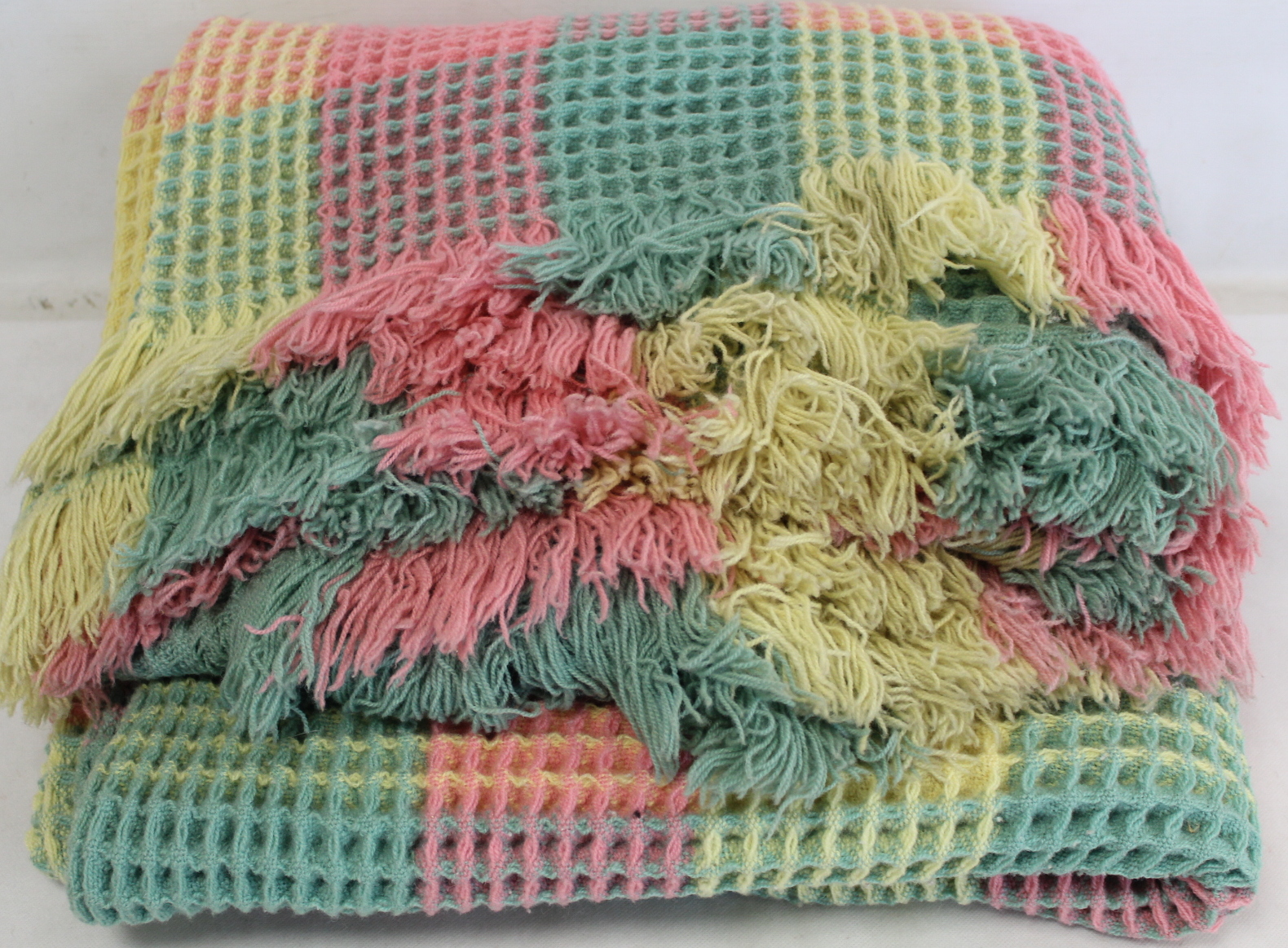 Welsh wool waffle blanket woven in pastel pink, yellow and green checks.
