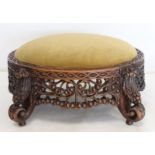 Eastern pierced and carved hardwood footstool of oval form with four scroll feet and foliate