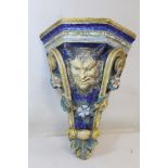Italian Maiolica terracotta corner wall bracket with satyr mask head with floral swag and scrolling,