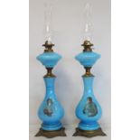 Pair of late 19th/early 20th century turquoise glass and gilt metal oil lamps, the baluster