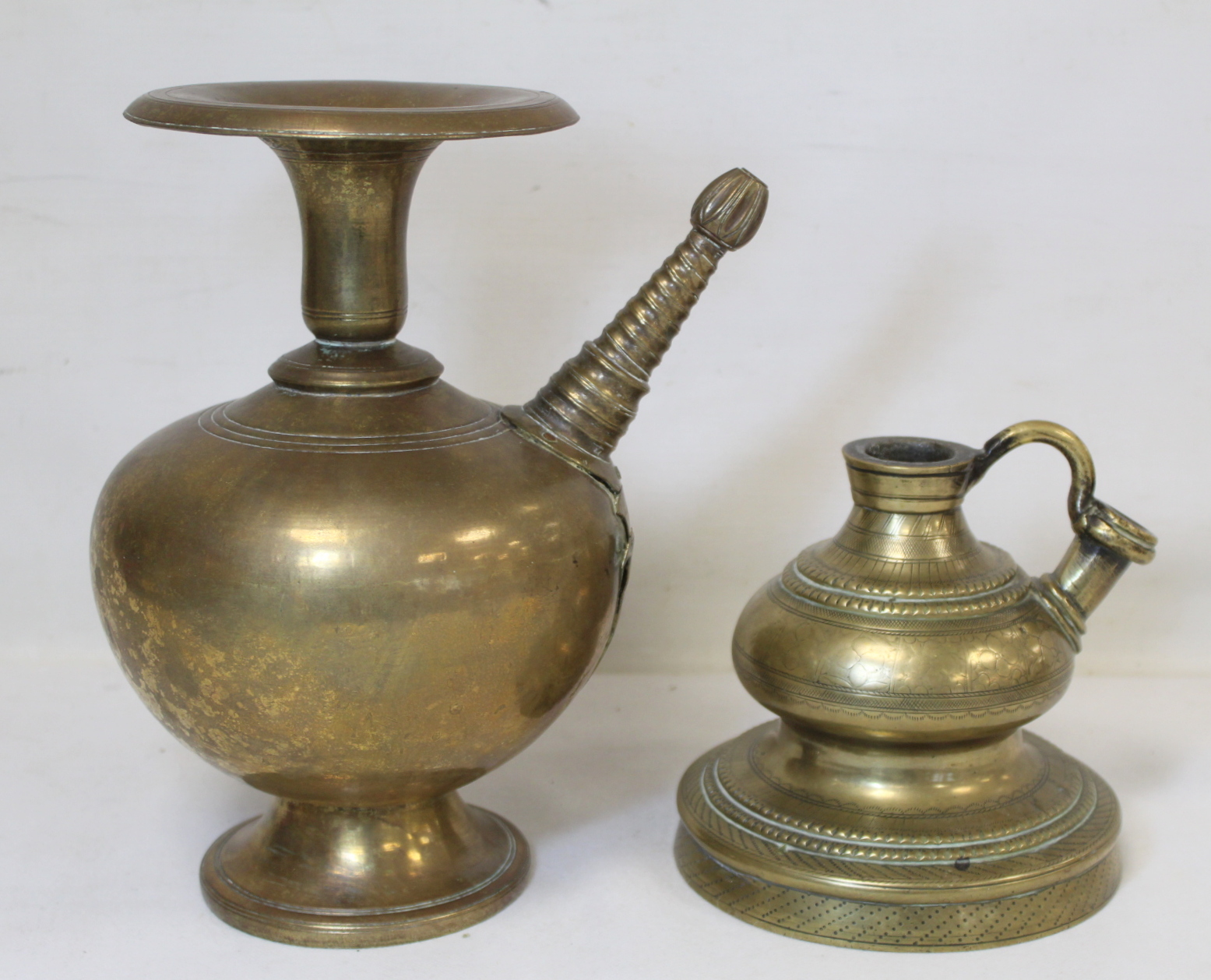 Two Eastern brass hookah bases, one of baluster form with flared rim, twisted conical spout with bud