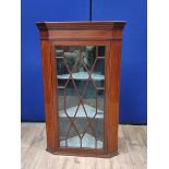 Georgian mahogany inlaid corner cabinet, with a glazed astragal door enclosing a shelved interior,