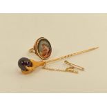 Victorian gold scarf pin with birds claw grasping a garnet bead and a 9ct gold ring with porcelain