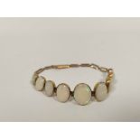 Opal bracelet with nine, collet set, the largest 14mm in gold, probably 9ct.