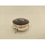 Silver inlaid tortoiseshell circular trinket box on shaped feet, 7cm.