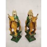 Mirror pair of Chinese pottery statues in the sancai palette depicting Shoulao astride his deer,