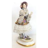Late 19th/early 20th century Continental porcelain figure of a young woman in floral bonnet and