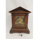 German mantel clock in carved oak case with pediment. 39cm.