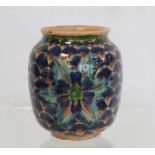 Small Iznik pottery vase of ovoid form decorated in blues, green and ochre with stylised flowerheads