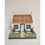 Vintage wooden painted model cottage with white walls and rush roof. H26cm