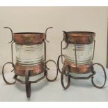 A pair of early 20th century ship's lanterns with wrought iron bases, copper frames and glass covers