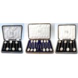 Set of twelve silver seal-end coffee spoons and tongs and two other sets of six, all cased.