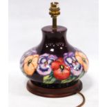 Moorcroft table lamp decorated with all-over floral decoration on an aubergine ground, 20cm high.