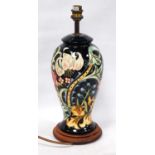 Moorcroft table lamp decorated all-over with floral panels on a blue ground, 27cm high.