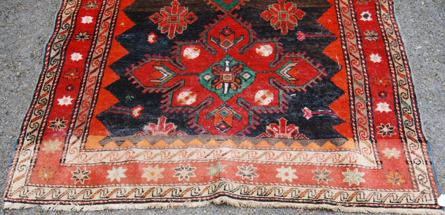 Afghan Belouch hand-knotted rug decorated with two large geometric motifs to the centre, on a red - Image 2 of 5