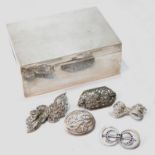 Silver cigarette box and five costume brooches.