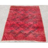 Afghan hand-knotted rug decorated with five rows of geometric medallions, on a red ground, 215cm x