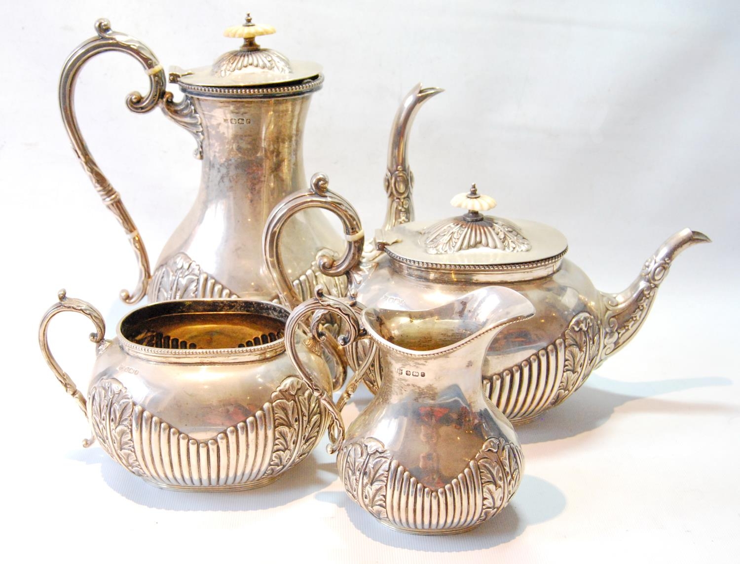 Silver four-piece tea and coffee set, ovoid with foliate and fluted embossing, by Deakins, Sheffield