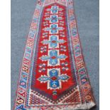 Turkish hand-knotted runner decorated with six geometric medallions to the centre, on a red