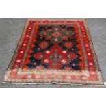 Afghan Belouch hand-knotted rug decorated with two large geometric motifs to the centre, on a red