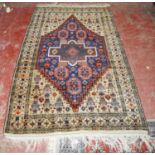 Afghan hand-knotted rug decorated with graduated geometric medallions on an orange and blue ground