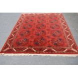 Afghan design rug decorated with five rows of three geometric medallions on a red ground with all-