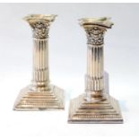 Pair of silver dwarf candlesticks with fluted Corinthian columns, Sheffield 1902, 12cm.