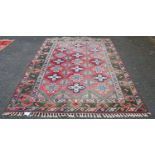 Turkish rug decorated with seven rows of three cross-shaped geometric medallions on a red ground,