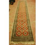 Turkish runner decorated with sixteen rows of two geometric medallions on a red ground with