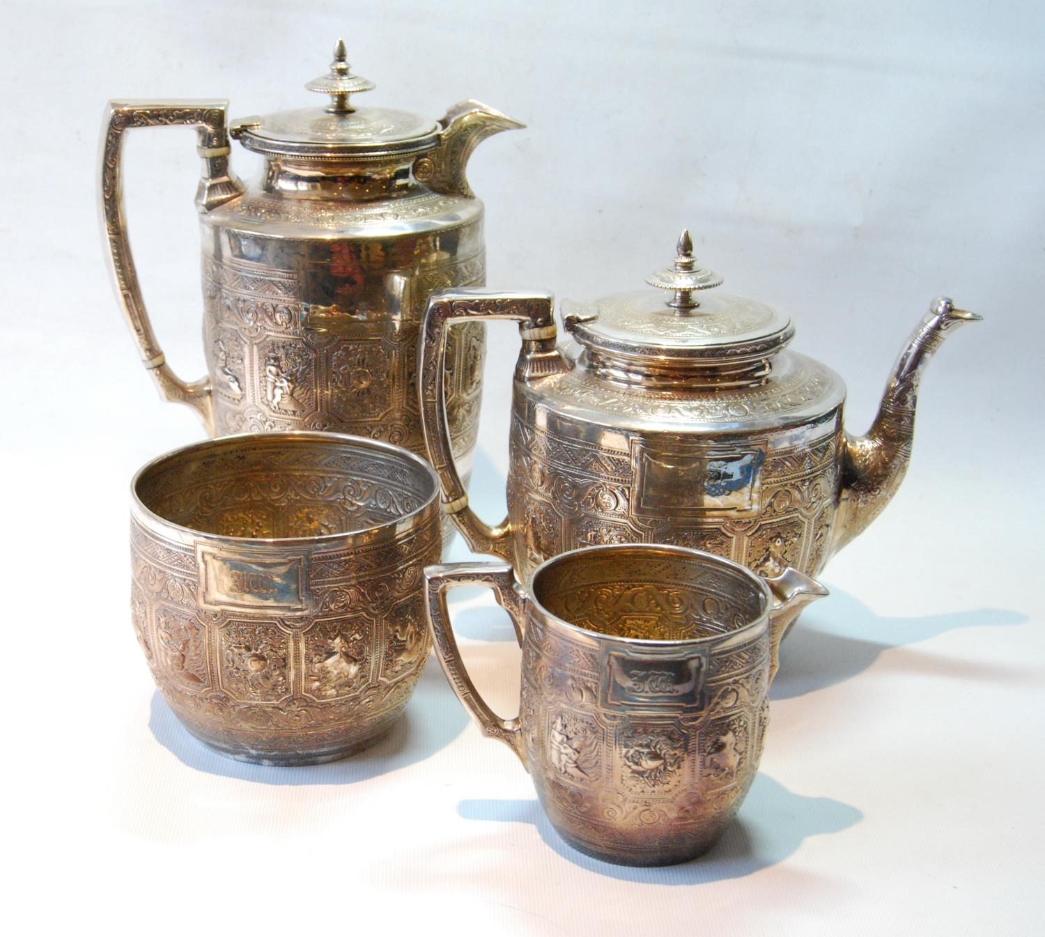 Four-piece silver tea set of ovoid shape embossed with the signs of the zodiac and bands of scrolls,