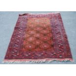 Afghan Belouch hand-knotted rug decorated with geometric medallions to the centre, on a red