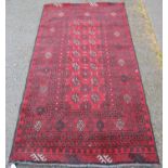 Afghan Belouch hand-knotted rug decorated with all-over geometric motifs, on a red ground, with a
