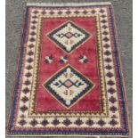 Turkish hand-knotted rug decorated with two geometric medallions to the centre, on a pink ground,