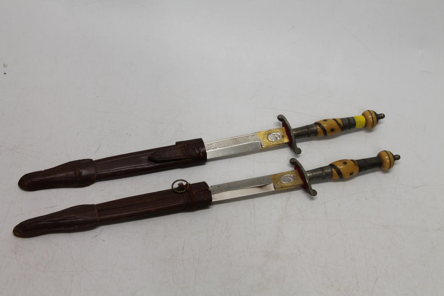 Pair of South American hunting knives, the ricasso marked "Rio Branco", in leather sheaths, blade