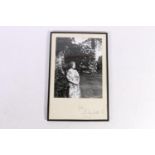 Photographic print of the Queen Mother in a garden, signed "from Elizabeth R" below, both pieces