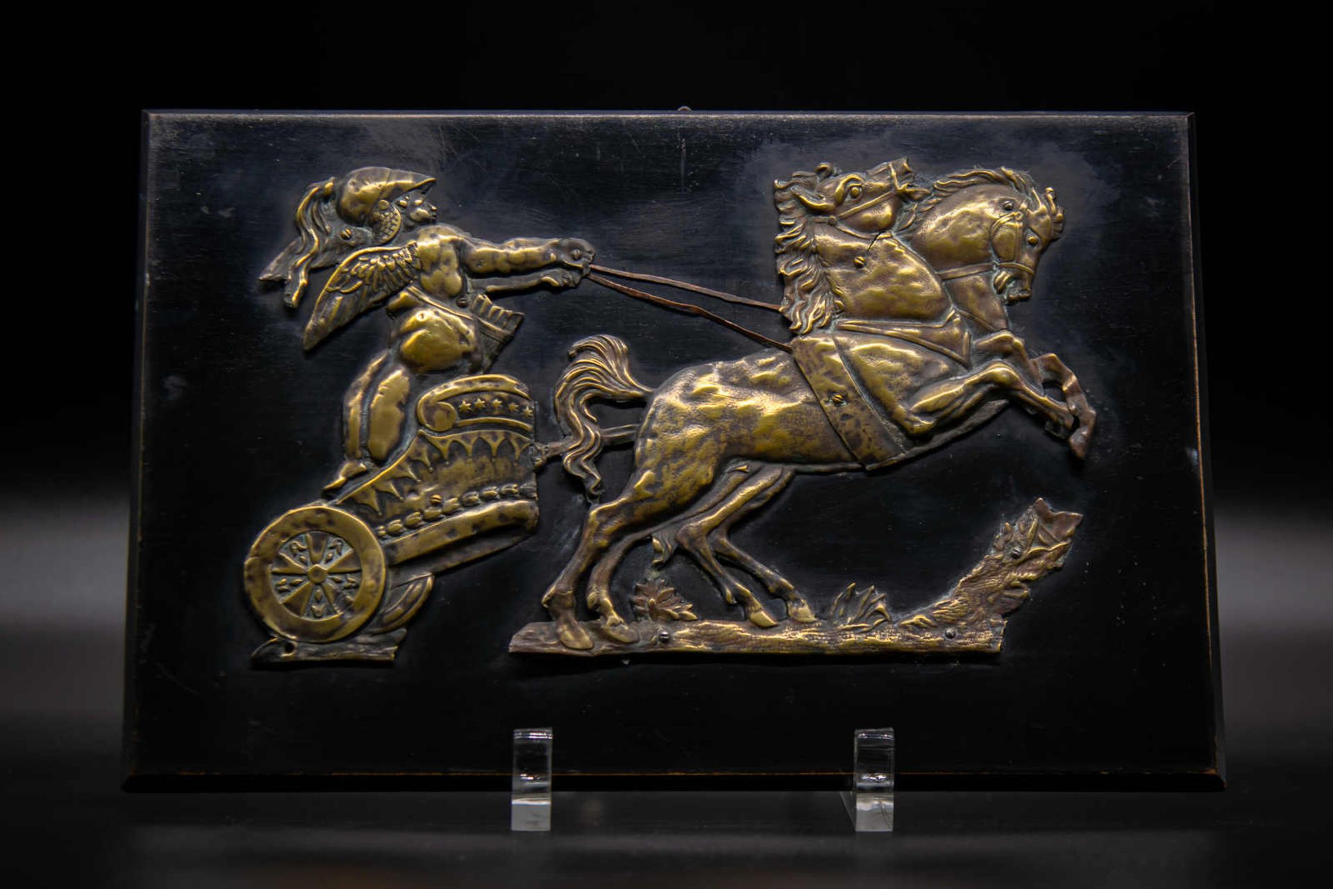 Antikisiertes Bronzerelief auf ebonisierter Platte. Gerüsteter Soldat mit Pferdegespann,