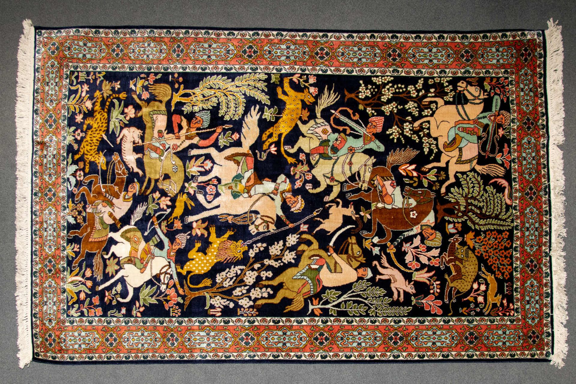 Orientteppich, wohl Ghom. Flor mit vielfiguriger Jagdszene, 3-geteilte Bordüre. Maße ca. 195 x 124